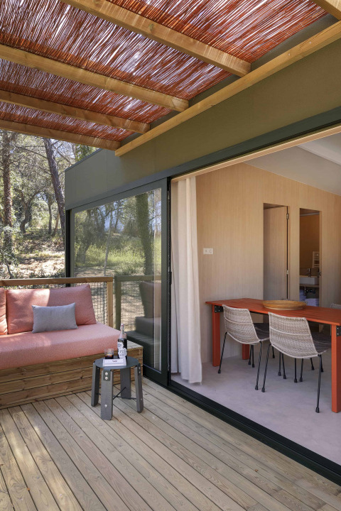 Terrasse extérieure du lodge Mobile Home Family au Wecamp Santa Cristina, Espagne, avec salon et table.