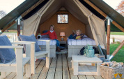 Two children in the Tiny Tent safari tent at Campsite Waddenzee in the Netherlands, cozy interior setup.