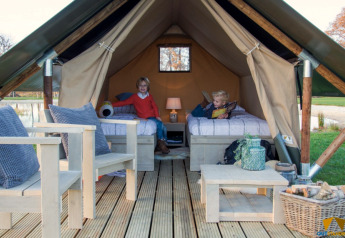 Twee kinderen in de safaritent Tiny Tent op Camping Waddenzee in Nederland, gezellig ingericht interieur.