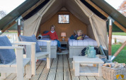 Two children in the Tiny Tent safari tent at Campsite Waddenzee in the Netherlands, cozy interior setup.