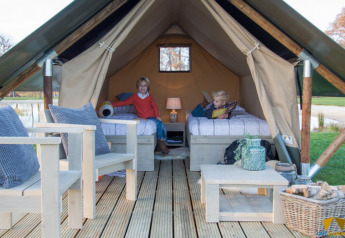 Dos niños en la tienda de safari Tiny Tent en el Camping Waddenzee en los Países Bajos, con interior acogedor.