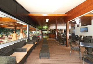 Lichte, moderne loungehoek in een stacaravan met comfortabele zitplaatsen en grote ramen, daglicht.