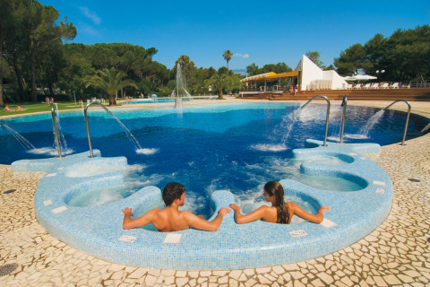 Twee mensen ontspannen in een jacuzzi bij het zwembad van Baia Domizia Villaggio Camping C3, Italië.