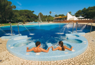 Twee mensen ontspannen in een jacuzzi bij het zwembad van Baia Domizia Villaggio Camping C3, Italië.