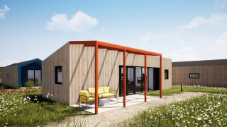 Moderne houten lodge bij Resort Callantsoog 5 met kleurrijk terras en zitplaats in het groen landschap.