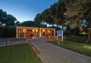 Avondbeeld van de fitnessruimte bij Baia Domizia Villaggio Camping in Italië, omgeven door bomen en groen.
