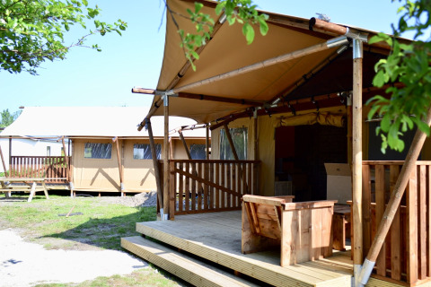 Safari tent at Beach Park Vlugtenburg 13 in the Netherlands with a wooden terrace and outdoor seating.