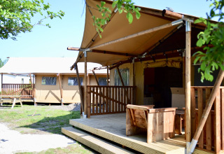 Tienda safari en Beach Park Vlugtenburg 13, Países Bajos, con terraza de madera y asientos exteriores.