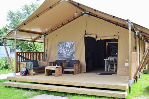 Tienda safari Beach Park Vlugtenburg 12 con terraza de madera, asientos cómodos y entrada abierta.