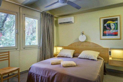 Dormitorio en casa móvil del resort Riva degli Etruschi San Vincenzo, con cama doble y decoración moderna.