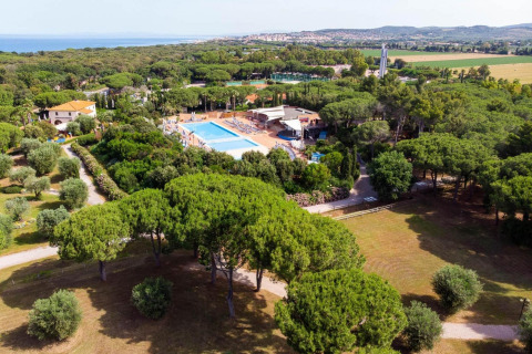 Resort vacacional Riva degli Etruschi San Vincenzo con piscina, árboles frondosos y playa cercana en Italia.