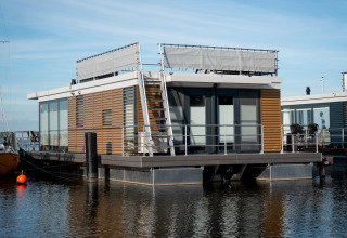 Casa flotante moderna llamada Houseboat «Elysium» con terraza sobre el agua en los Países Bajos.
