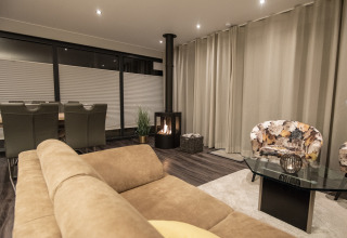 Modernes Wohnzimmer im Hausboot Elysium in den Niederlanden mit Kamin, Sofa und Essbereich.