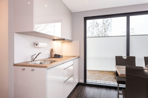 Moderna cucina e zona pranzo sulla houseboat 'Elysium' nei Paesi Bassi con ampie finestre luminose.