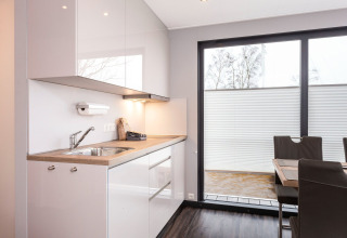 Moderna cucina e zona pranzo sulla houseboat 'Elysium' nei Paesi Bassi con ampie finestre luminose.