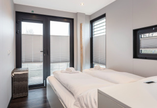 Dormitorio en la casa flotante Elysium en Países Bajos con camas individuales y decoración moderna.