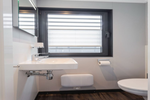 Modernes Badezimmer auf dem Hausboot Elysium mit Fenster, Waschbecken und Toilette in den Niederlanden.