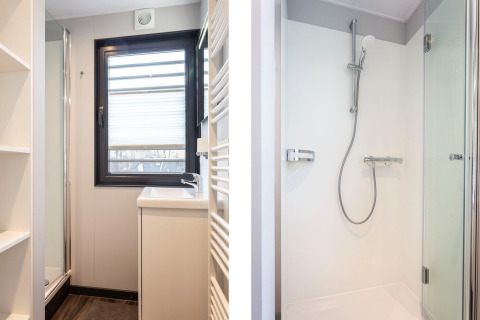 Bagno moderno e luminoso con finestra e doccia sulla houseboat 'Elysium' nei Paesi Bassi.