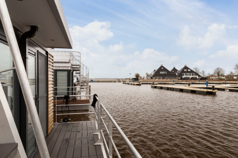 Vista dalla houseboat Elysium nei Paesi Bassi con pontili e tipiche costruzioni olandesi.