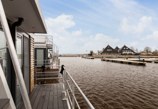 Vista dalla houseboat Elysium nei Paesi Bassi con pontili e tipiche costruzioni olandesi.