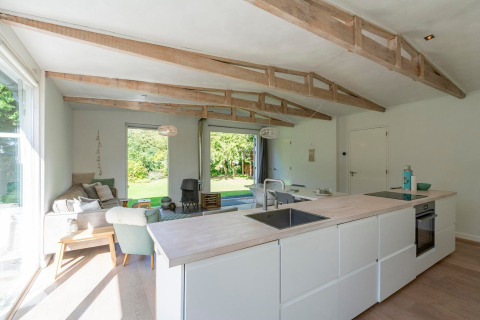 Lyst og moderne interiør i lodge Eureka 109 i Holland med fritlagte bjælker og hyggelig siddekrog.