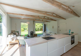 Lyst og moderne interiør i lodge Eureka 109 i Holland med fritlagte bjælker og hyggelig siddekrog.