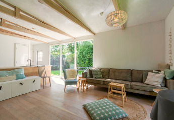 Salon lumineux et spacieux du lodge Eureka 109 aux Pays-Bas avec grande baie vitrée et mobilier moderne.