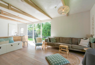 Lyst og rummeligt opholdsområde i lodge Eureka 109 i Holland med moderne møbler og store vinduer.