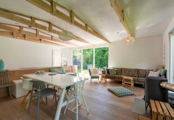 Espace de vie moderne et lumineux d’Eureka 109, Pays-Bas, avec poutres apparentes en bois et grandes fenêtres.