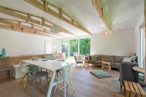 Lyst, moderne opholdsområde i lodge Eureka 109, Holland, med store vinduer og træloftsbjælker.