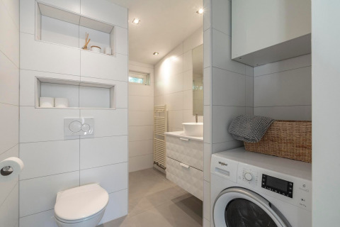 Moderne badeværelse med vaskemaskine, toilet, håndvask og indbyggede hylder på Eureka 109, Holland.