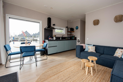 Lyst og moderne opholdsområde på husbåd RiggelBrug Sneekermeer med udsigt over kanalen i Holland.