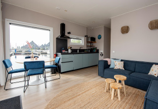 Lyst og moderne opholdsområde på husbåd RiggelBrug Sneekermeer med udsigt over kanalen i Holland.