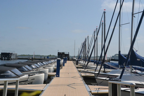Både ligger fortøjet ved en gangbro ved husbåden RiggelBrug Sneekermeer i Nederlandene på en solskinsdag.