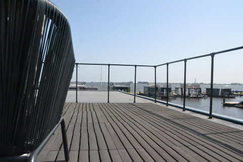 Udsigt fra dækket af husbåden RiggelBrug Sneekermeer med søudsigt og både i Holland.