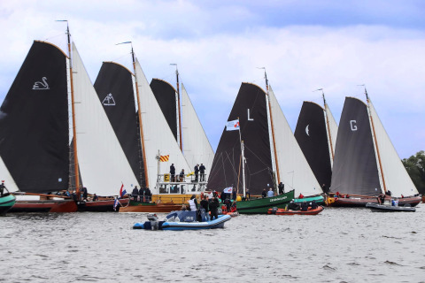 Sejlbåde og ledsagebåde samles på søen ved Sneekermeer, fotograferet fra husbåden RiggelBrug.