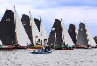 Sejlbåde og ledsagebåde samles på søen ved Sneekermeer, fotograferet fra husbåden RiggelBrug.