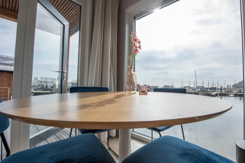 Udsigt fra spisebord på husbåden RiggelBrug Sneekermeer over en marina i Nederlandene.