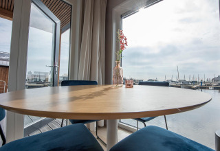 Udsigt fra spisebord på husbåden RiggelBrug Sneekermeer over en marina i Nederlandene.