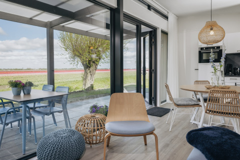 Lys stue i Park Wijdenes 4 med moderne indretning og udsigt over det smukke hollandske landskab.