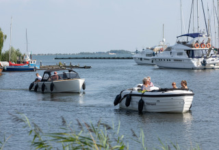 Folk sejler i både ved en havn ved Park Wijdenes 3 i Holland, med yachter og små både i baggrunden.