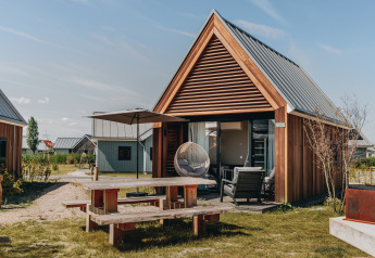 Tiny house moderne au Beach Resort Nieuwvliet-Bad avec terrasse extérieure, mobilier et bardage bois.