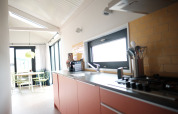 Lyst og moderne køkken og spiseområde i Resort Callantsoog 2 med pastelfarver i Holland.