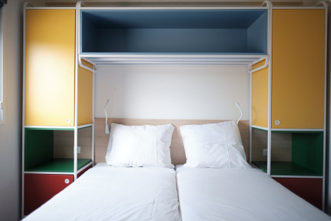 Twee enkele bedden met kleurrijke kasten in Resort Callantsoog 2 in Nederland, modern en licht.