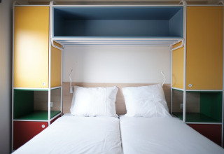 Twee enkele bedden met kleurrijke kasten in Resort Callantsoog 2 in Nederland, modern en licht.