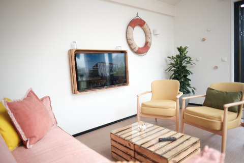 Heldere en gezellige leefruimte in Resort Callantsoog 2 in Nederland met kleurig meubilair en maritieme accenten.
