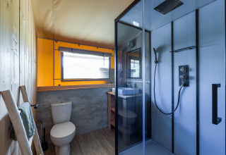 Modern bathroom interior of a safari tent at Villa Holiday Park IJsselhof, Netherlands, with shower and toilet.
