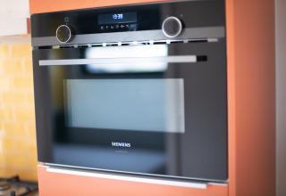 Siemens inbouwoven met digitaal scherm in een keuken van Resort «Callantsoog 2» in Nederland.