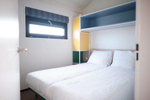 Lichte kamer met twee aparte bedden in Resort Callantsoog 2, Nederland, hedendaags ingericht en raam.