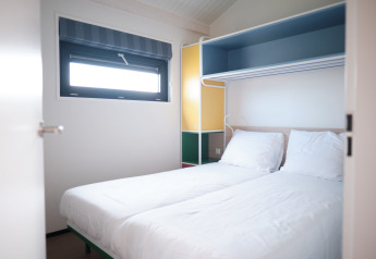 Lyst værelse med to enkeltsenge på Resort Callantsoog 2, Holland, med moderne møbler og vindue.